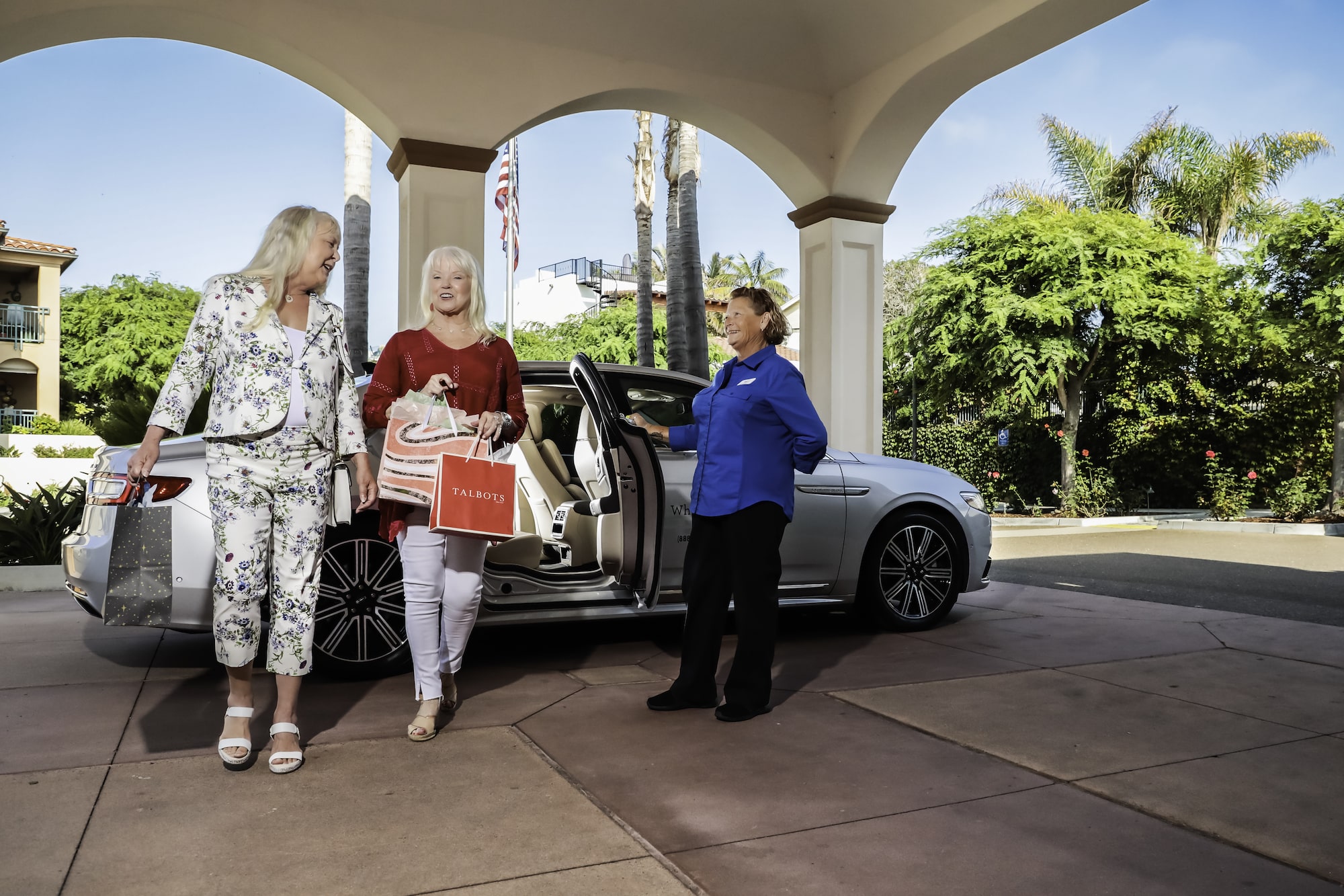 Two women returning from shipping in a Human Good courtesy car